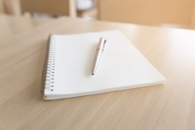 Tükenmez kalem ve defter ahşap masa