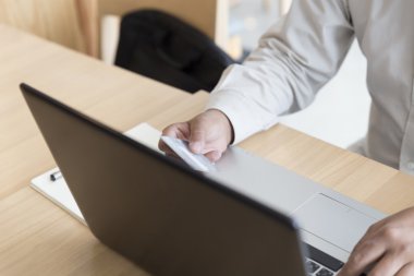 Paym için dizüstü bilgisayar ve kredi kartı ile işadamı eli