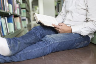 adam koridorda kitaplığındaki kitap okumak