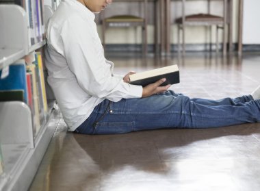 adam koridorda kitaplığındaki kitap okumak