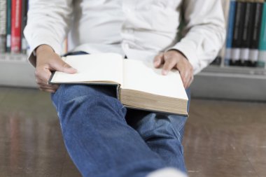 adam koridorda kitaplığındaki kitap okumak