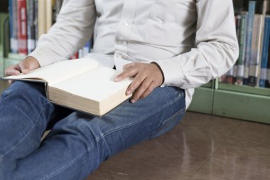 adam koridorda kitaplığındaki kitap okumak