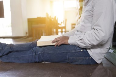 adam koridorda kitaplığındaki kitap okumak