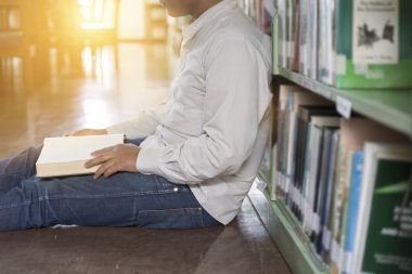 adam koridorda kitaplığındaki kitap okumak