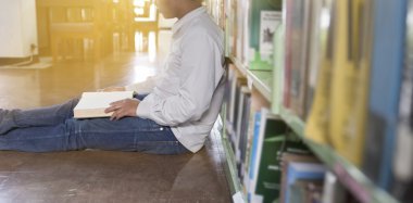 adam koridorda kitaplığındaki kitap okumak