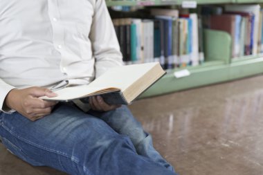 adam koridorda kitaplığındaki kitap okumak