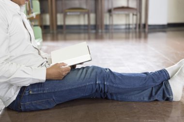 adam koridorda kitaplığındaki kitap okumak