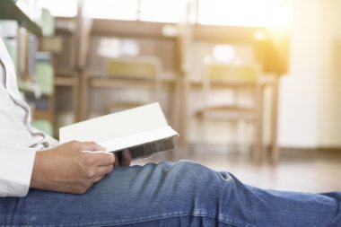 adam koridorda kitaplığındaki kitap okumak