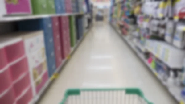 Cart, aisle and product selling in supermarket - blur for use as — Stock Photo, Image