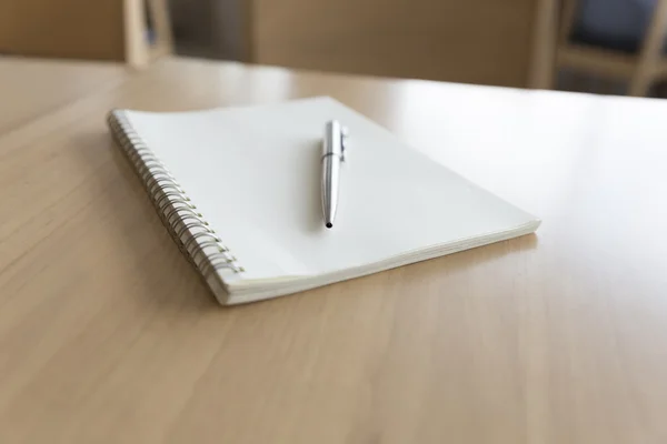 Caneta esferográfica e notebook em mesa de madeira — Fotografia de Stock