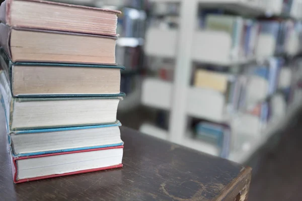 나무 테이블에 오래 된 책 도서관 배경 흐림 — 스톡 사진