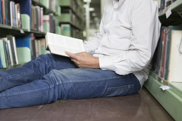 adam koridorda kitaplığındaki kitap okumak