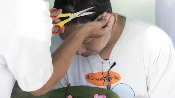 As pessoas cortam o cabelo do homem que se tornará monge budismo em ordinati — Fotografia de Stock