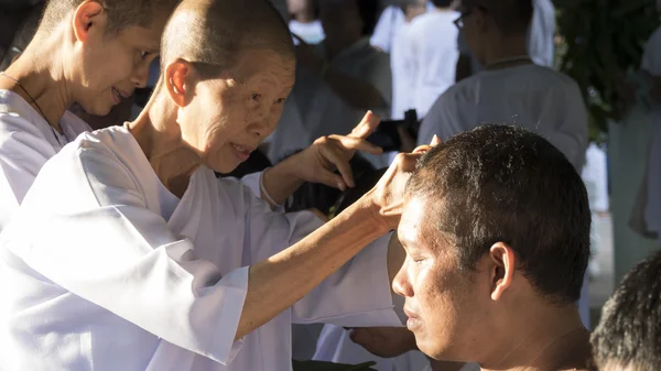 Menschen schneiden Haare eines Mannes, der in Ordinati zum Buddhismus-Mönch wird — Stockfoto