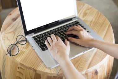 ahşap masa üzerine gözlük ile bilgisayar dizüstü kadın eli