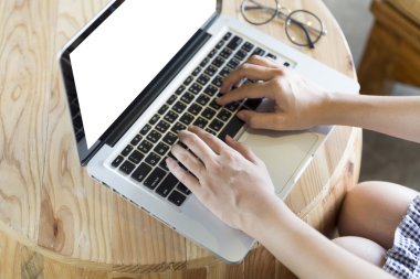 ahşap masa üzerine gözlük ile bilgisayar dizüstü kadın eli