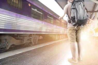 sırt çantası ile harita tren istasyonunda tutan adam