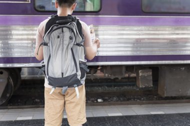 sırt çantası ile harita tren istasyonunda tutan adam