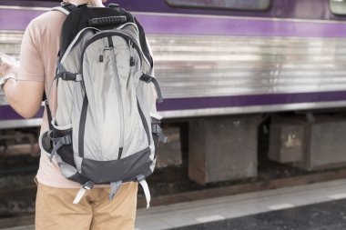 sırt çantası ile harita tren istasyonunda tutan adam