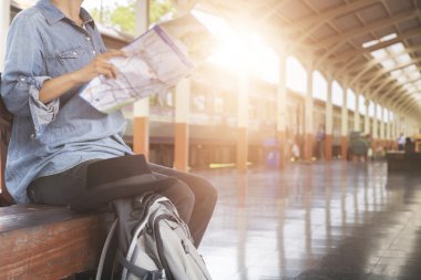 sırt çantası ile harita tren istasyonunda tutan kadın