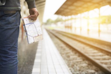 Tren istasyonunda elinde harita tutan adam.