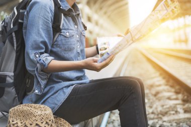 sırt çantası ile harita tren istasyonunda tutan kadın