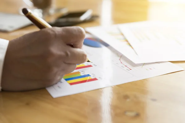 Zakenman hand met pen met grafiek en grafiek analyse papier — Stockfoto