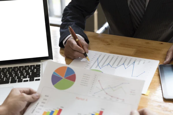 Empresário analisando e discutindo com computador e papelada — Fotografia de Stock