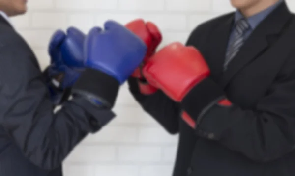 Biznesmen w garniturze z czerwonymi i niebieskimi rękawiczkami bokserskimi — Zdjęcie stockowe
