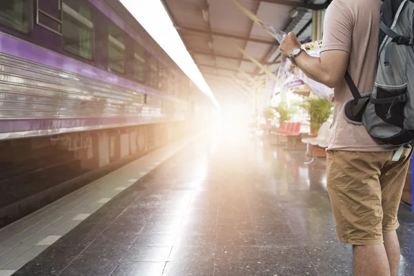 Man håller karta med ryggsäck på tågstationen — Stockfoto