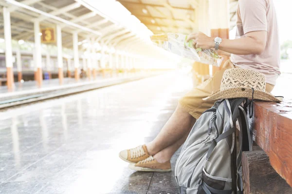 Homem segurando mapa com mochila na estação de trem — Fotografia de Stock