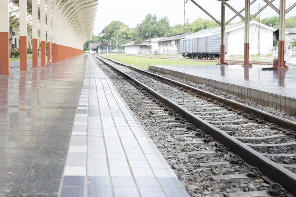 Plataforma ao lado da ferrovia na estação de trem — Fotografia de Stock