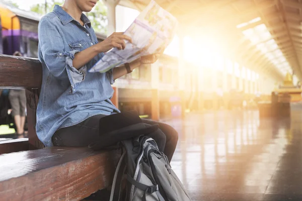 Mulher segurando mapa com mochila na estação de trem — Fotografia de Stock