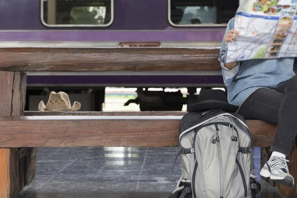 Kvinna med karta med ryggsäck på tågstationen — Stockfoto
