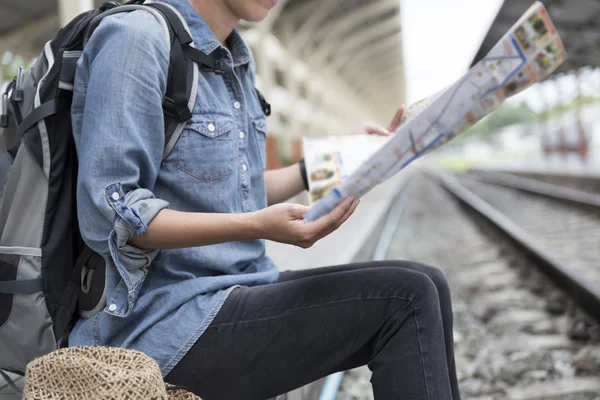 Vrouw met kaart met rugzak op station — Stockfoto