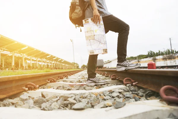 Mulher segurando mapa com mochila na estação de trem — Fotografia de Stock