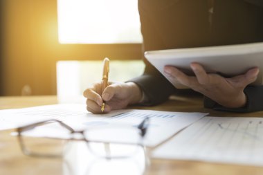 Takım elbiseli işadamı, pazar analizi için tablet kullanıyor.