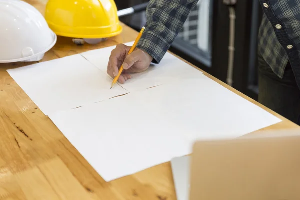 Architect working on blueprint of construction project in workpl — Stock Photo, Image