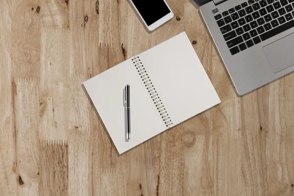 Laptop, Smartphone, Stift, Notizbuch auf Holzschreibtisch - Arbeitsgerät — Stockfoto