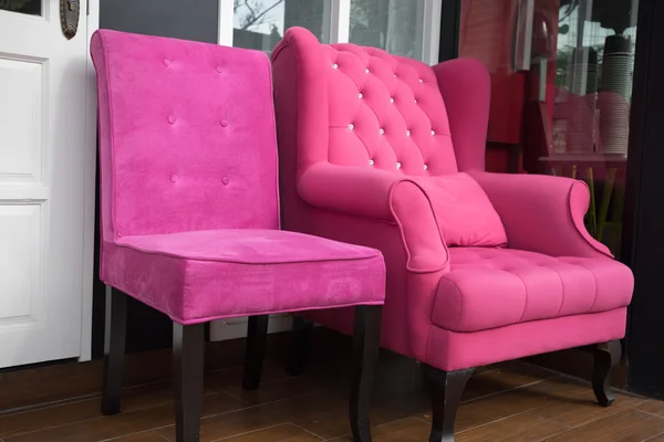 白い扉の横にあるピンクの生地の肘掛け椅子 — ストック写真