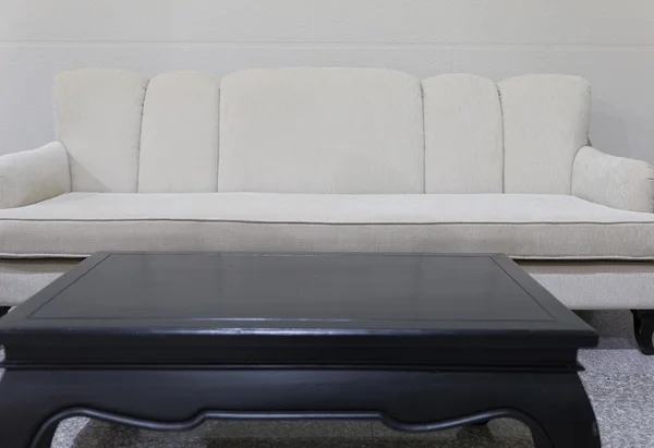 Beige tyg soffa soffa och svart skrivbord — Stockfoto
