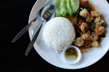 Mürekkep balıklı pilav fesleğenle kızartılmış kalamar balığı. Asya yemekleri.