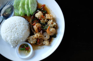 Mürekkep balıklı pilav fesleğenle kızartılmış kalamar balığı. Asya yemekleri.