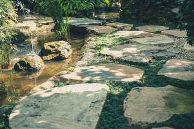 Bahçe parkında taş döşenmiş gölet.