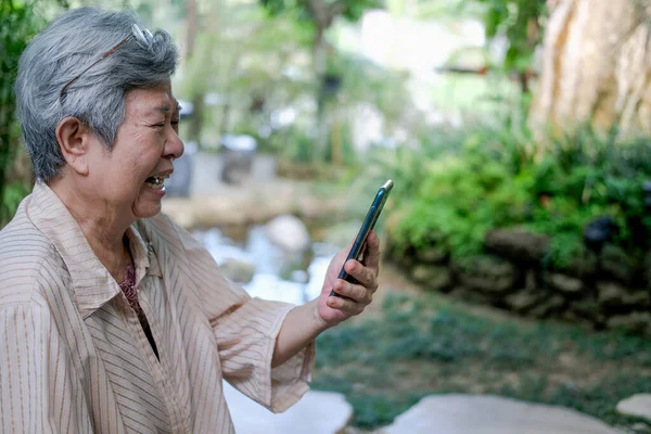 忧心忡忡的亚洲老年人老年妇女在智能手机上通过视频通话 — 图库照片