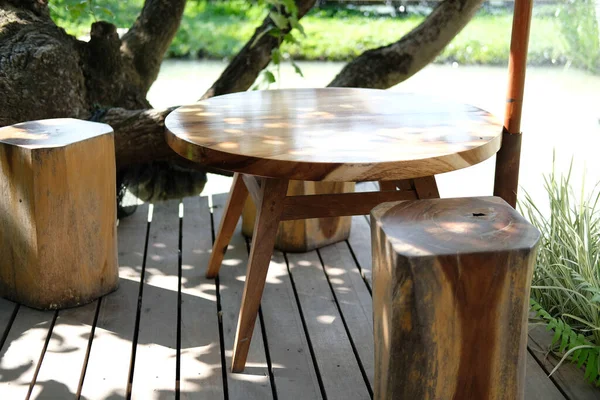 餐厅池塘边的露台上的木制凳子和桌子 — 图库照片