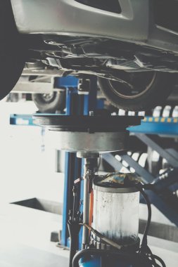 Otomobil tamirhanesindeki arabadan eski motor yağı doldurmak için motor yağı konteynırı