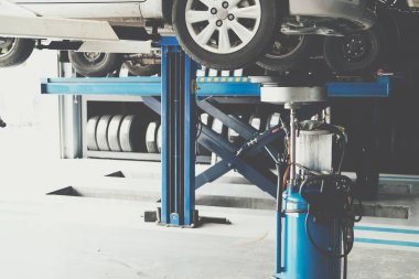 Otomobil tamirhanesindeki arabadan eski motor yağı doldurmak için motor yağı konteynırı