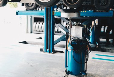 Otomobil tamirhanesindeki arabadan eski motor yağı doldurmak için motor yağı konteynırı