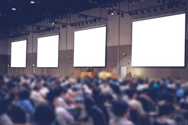 Seminer konferans odasında sahne ve sunum ekranı. Bulanık arkaplan